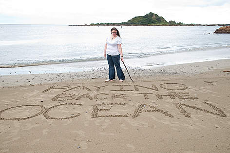 Rachel Sawaya writing the title of her winning story, Paying Back the Ocean in the sand at Island ... / &copy;: Louise Hatton / WWF-New Zealand