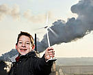 Child holding a small wind turbine to show that it is the solution for a sustainable future energy, Charleroi, Belgium.